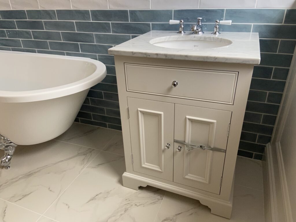 Traditional-style bathroom vanity unit with marble basin and chrome taps in Weybridge bathroom installation