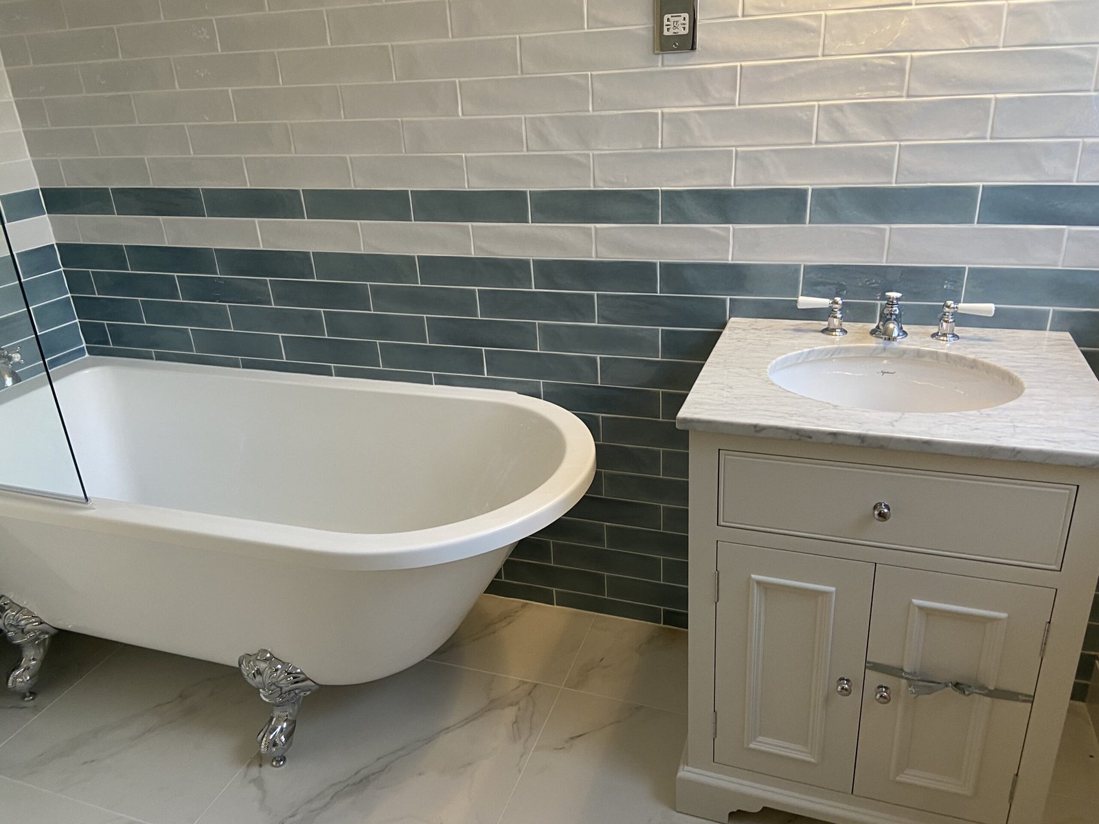 Traditional style bathroom with freestanding bath and marble vanity unit installed by Summer Plumbing in Esher