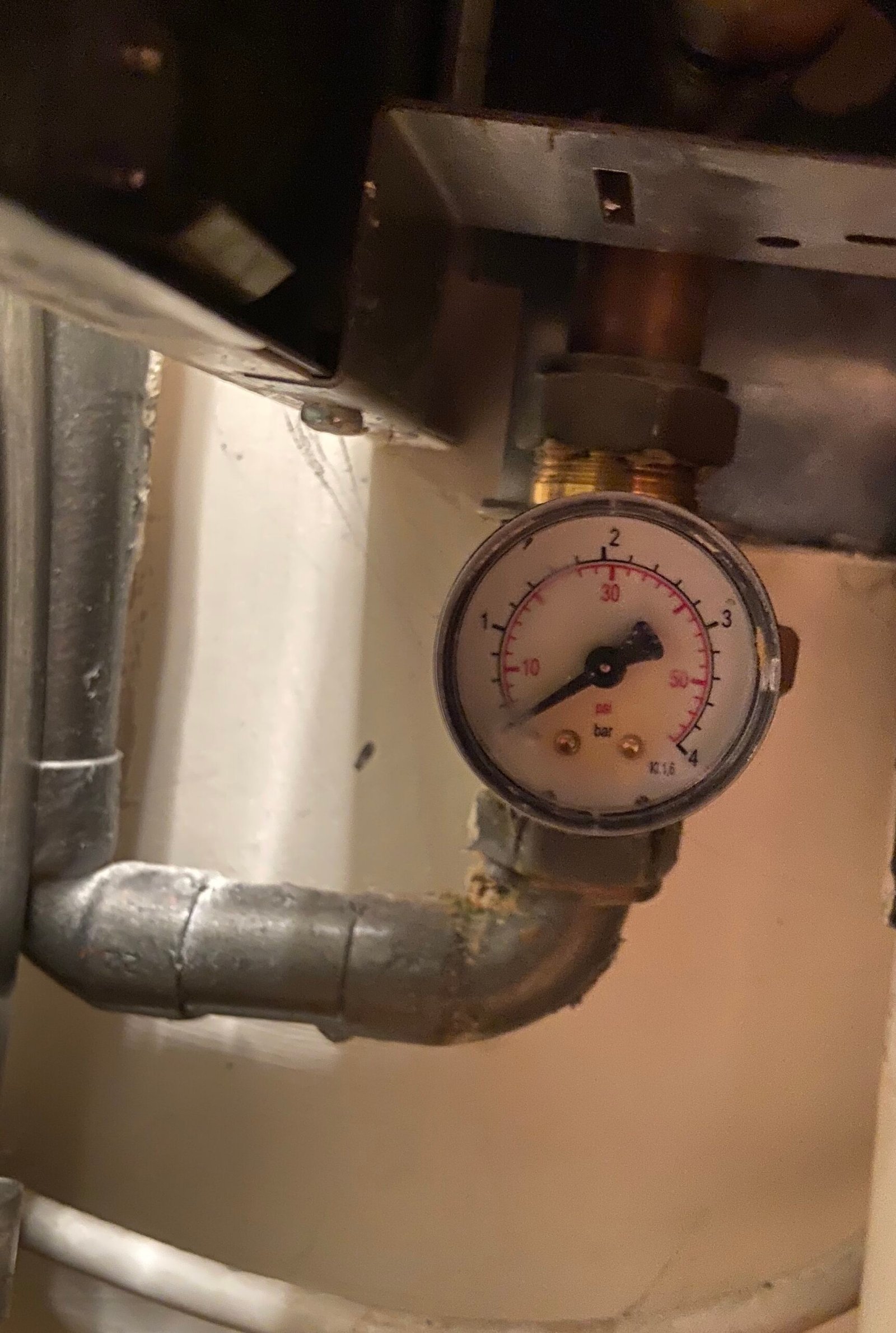 Close-up of a boiler pressure gauge showing under 1 bar, inspected during a plumbing service in Weybridge.